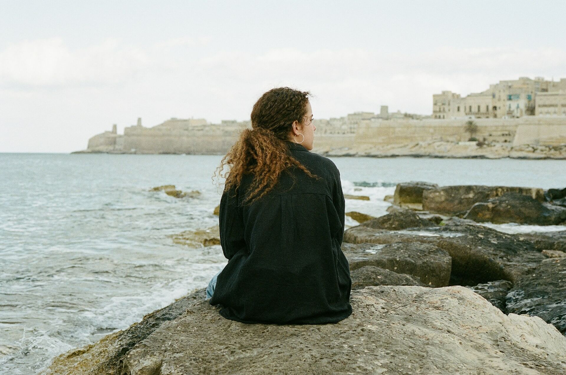 34 A girl sitting on a rock by the sea