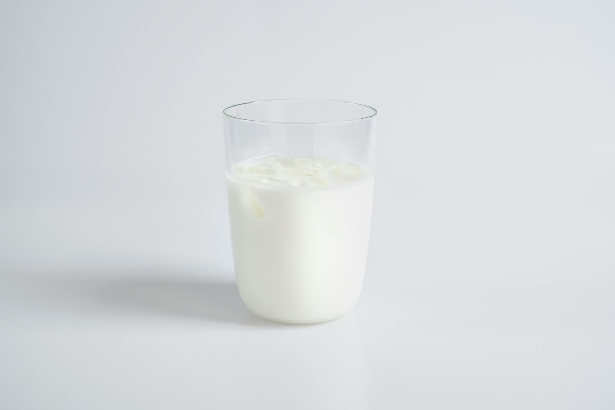 A clear glass filled with cold milk against a soft white background. (Photo Credit: An Vision)