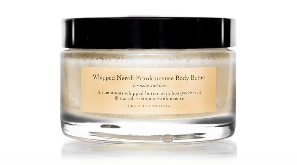 Glass jar of Evanhealy whipped neroli frankincense body butter with black lid and tan label on white background, certified organic formula for body and face with honeyed neroli and resinous frankincense (Photo Credit: Evanhealy)