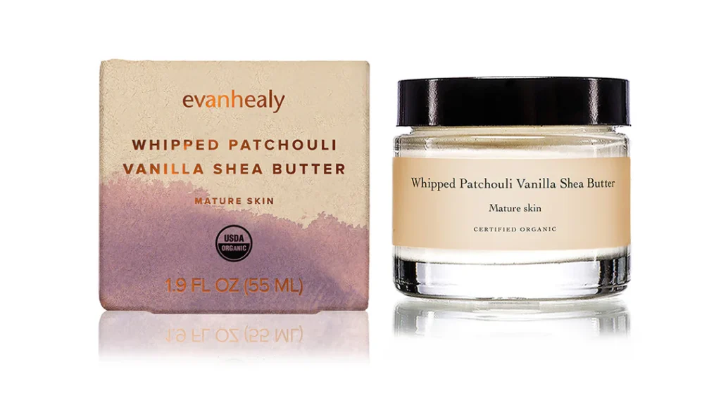 Evanhealy whipped patchouli vanilla shea butter in glass jar with black lid next to product box, certified organic 1.9oz formula for mature skin (Photo Credit: Evanhealy)